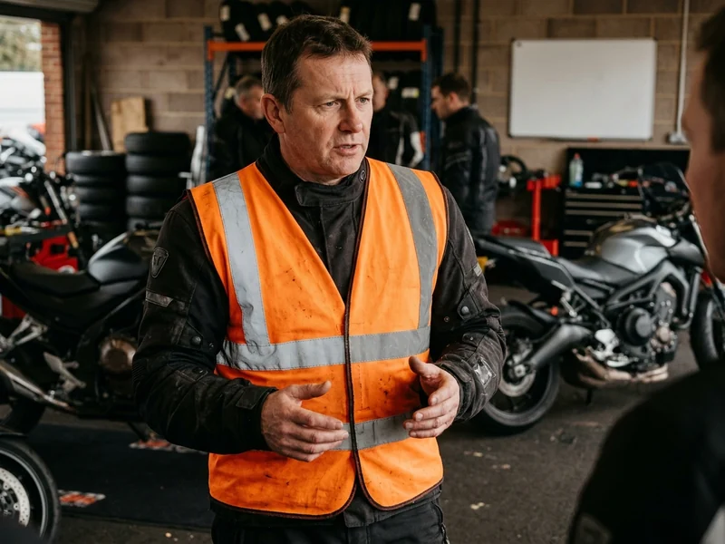 High-visibility instructor vest with reflective strips worn over a riding jacket